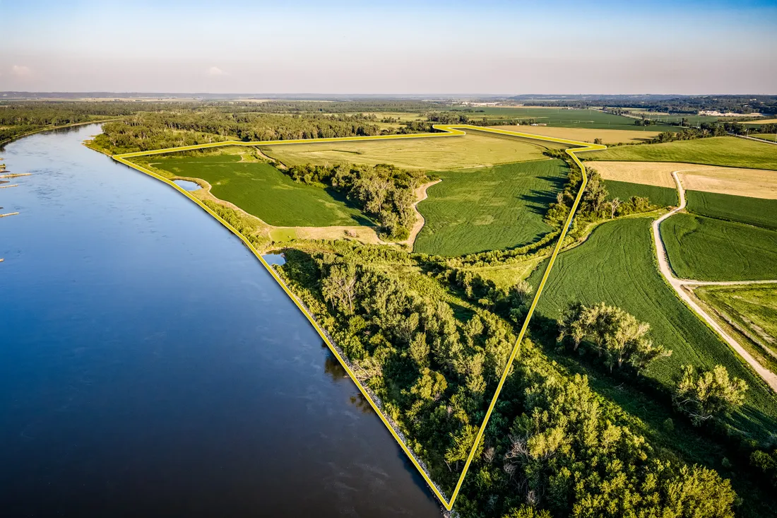 Aerial view of farmland and river property with a surveyed boundary line overlay