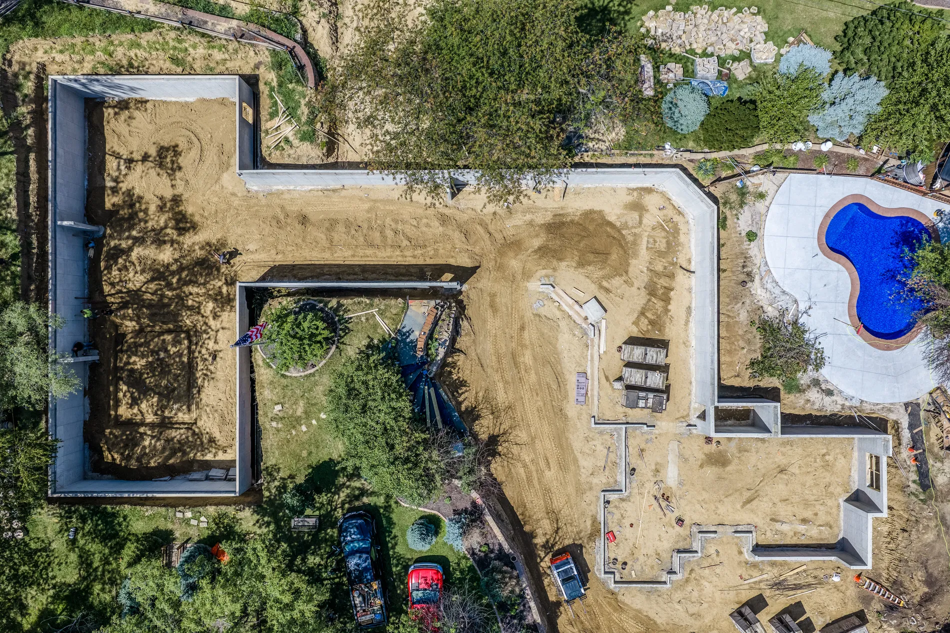 Straight-down aerial view of a home under construction with an in-ground pool being built