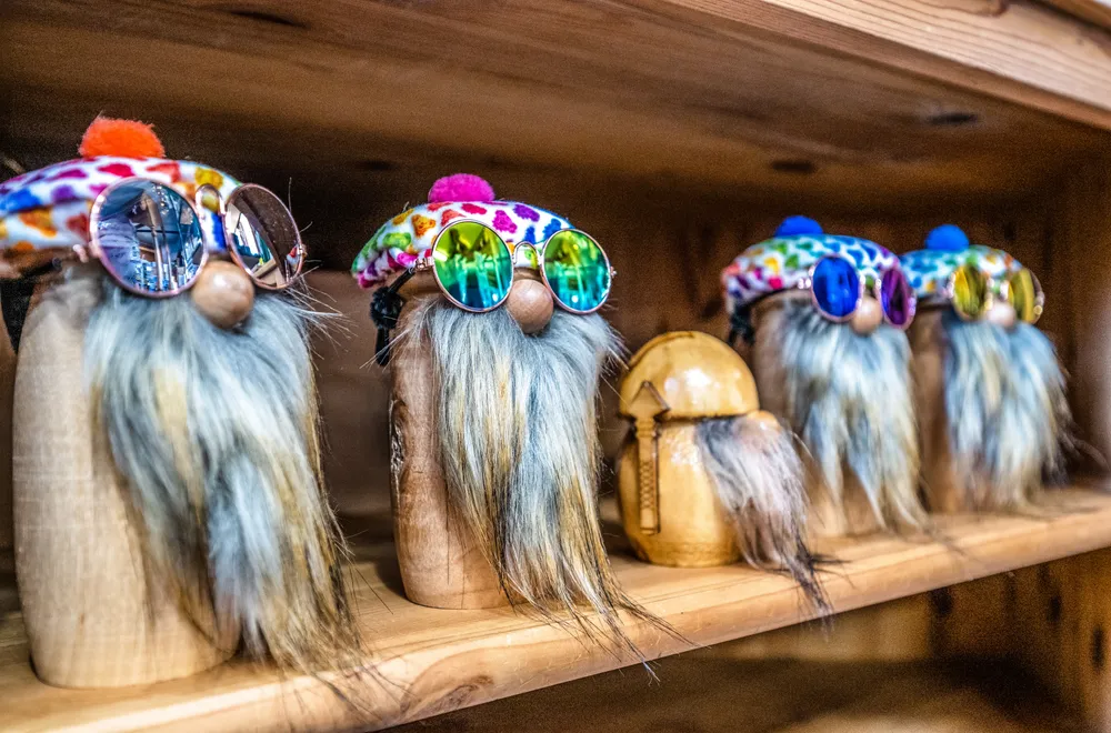 Whimsical bottle-cap gnome figurines styled on a wooden shelf