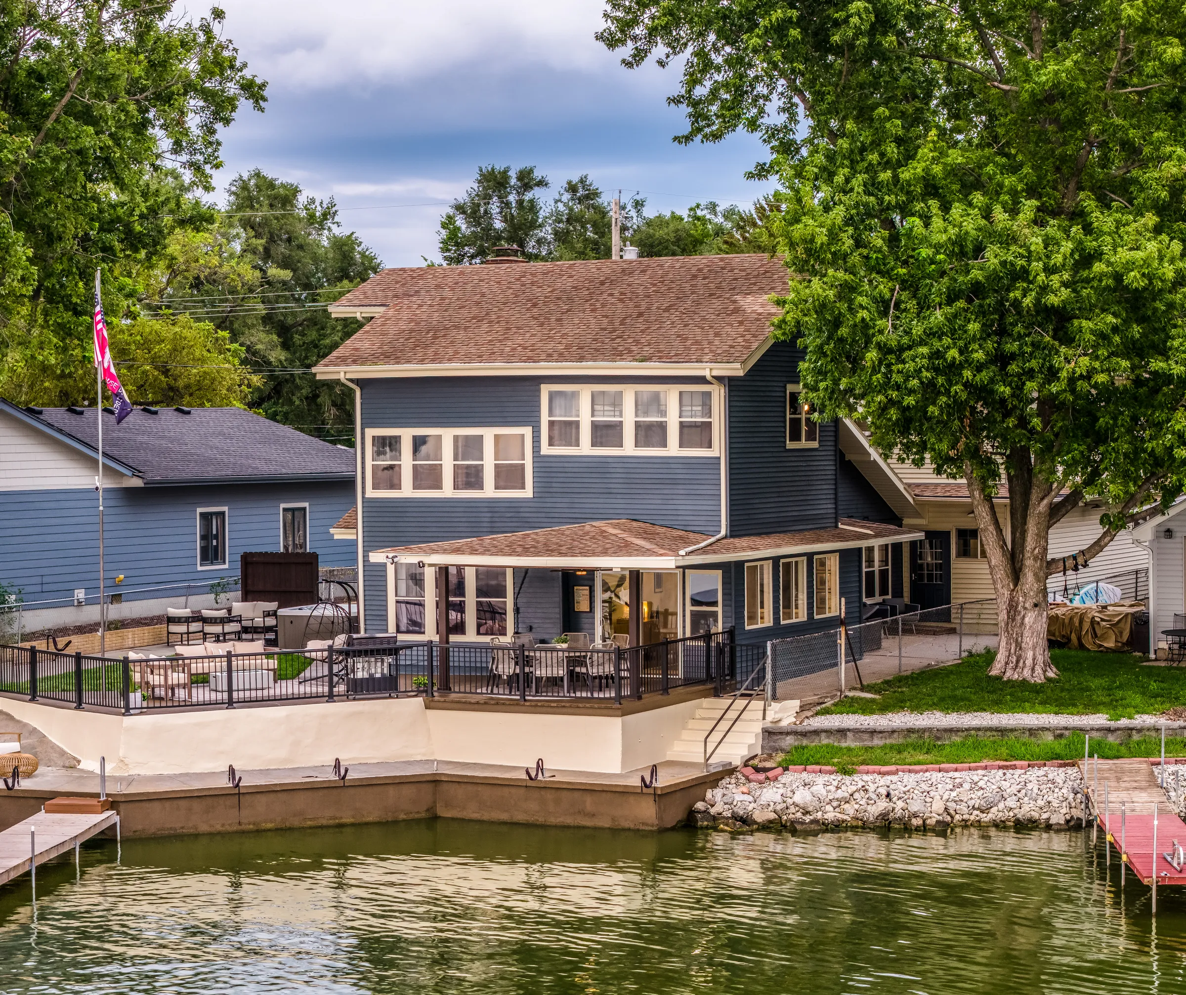 Aerial view of a blue lakefront home with a private dock